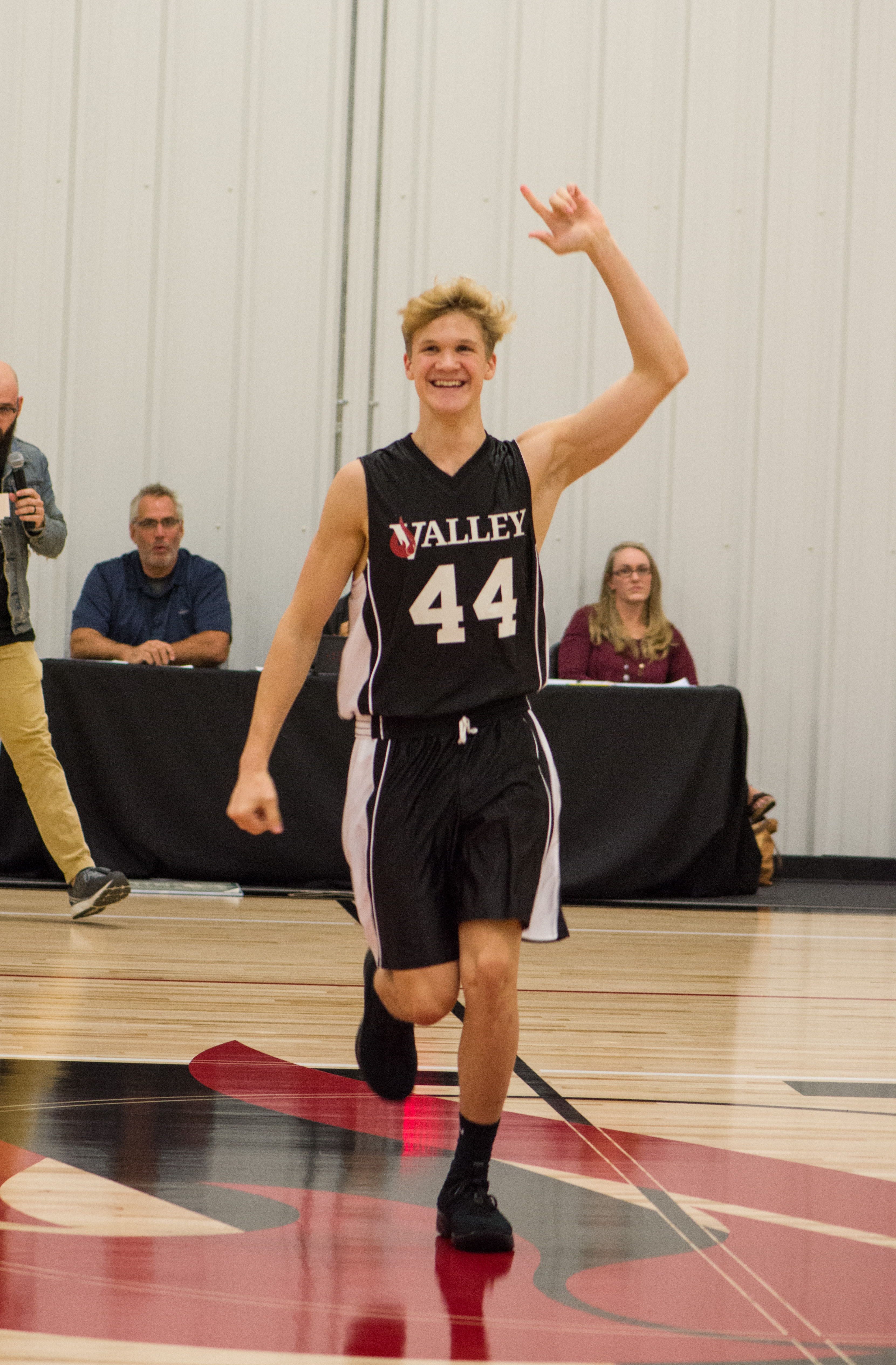 Teenage boy smiling and celebrating while playing basketball 