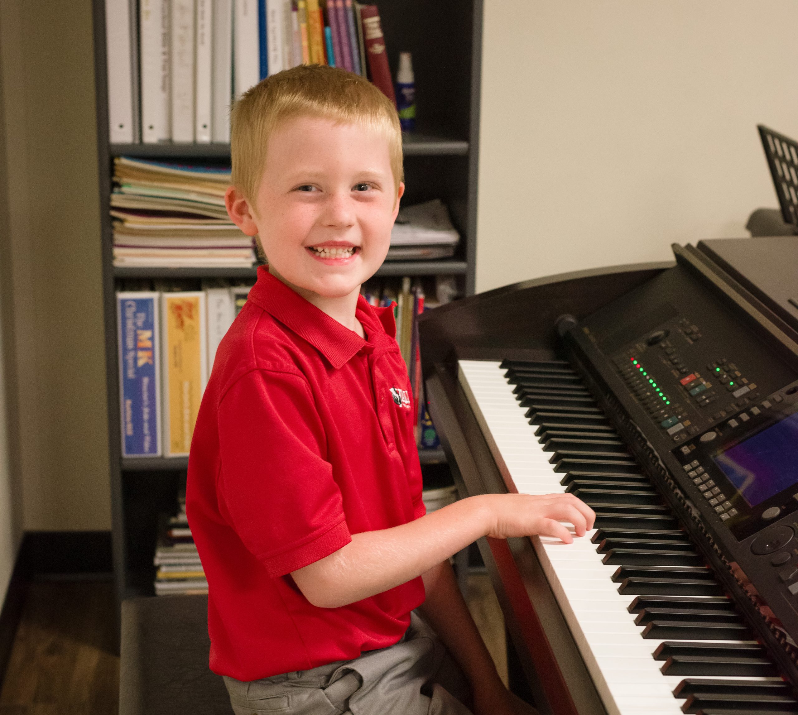 VFCA elementary student smiling while playing piano